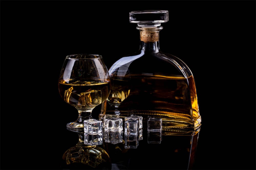 A snifter glass of brandy and a brandy decanter