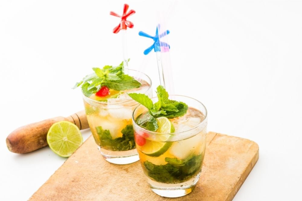 Mint Julep with mint, lime, and cherry on a wooden plate