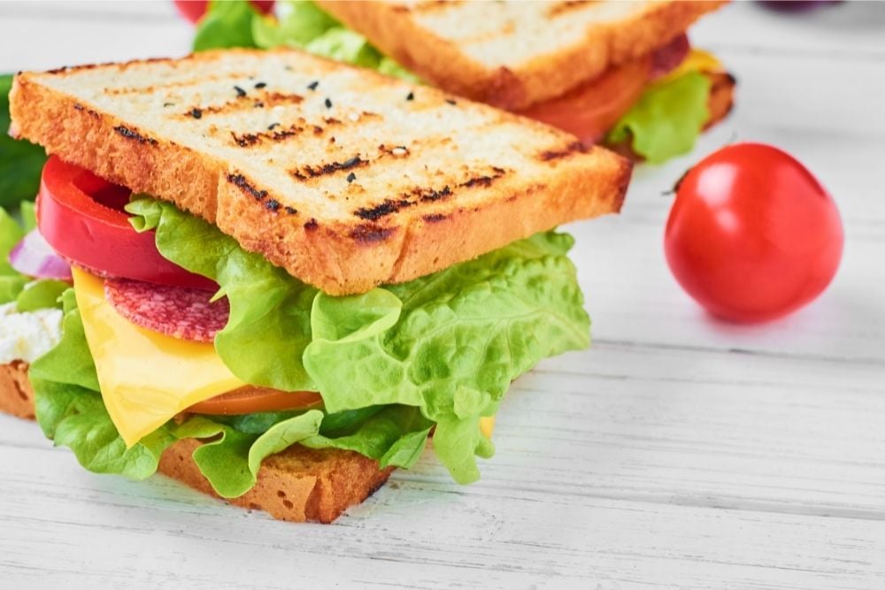 Vegetable Sandwich with ham, lettuce, tomatoes, onion, and cheese