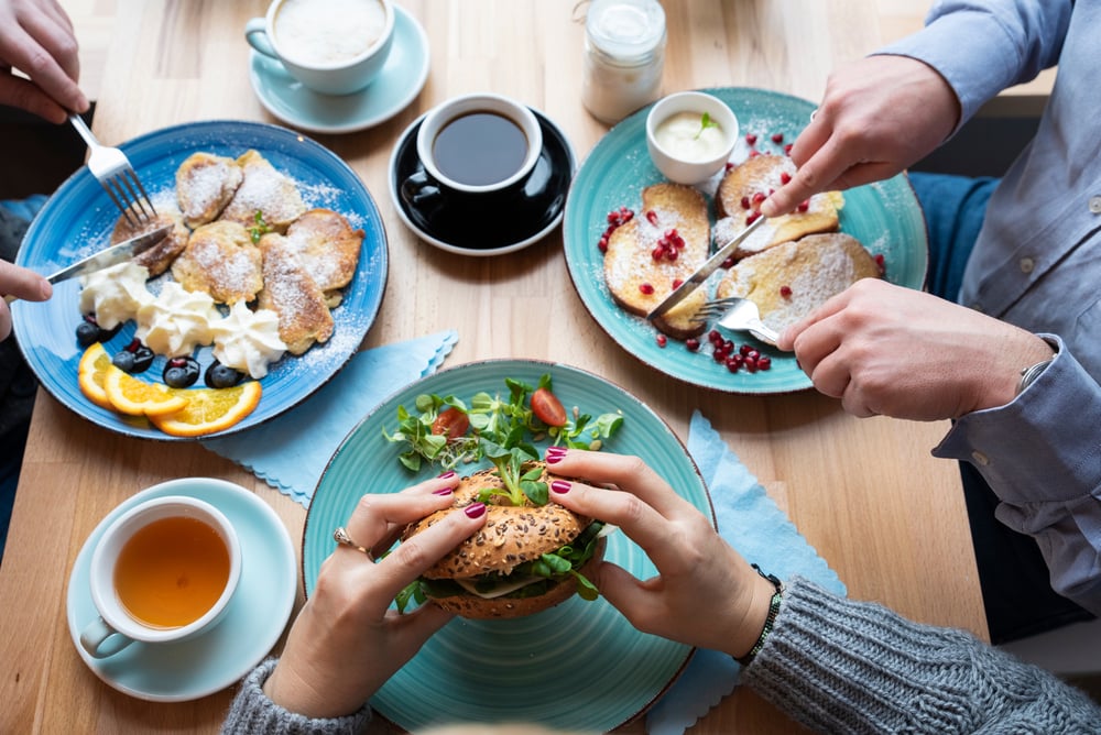 group of friends eating pancake and breakfast burger for brunch at a restaurant in New Orleans