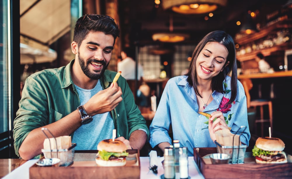 young couple eating burger and fries at a restaurant in Tribeca