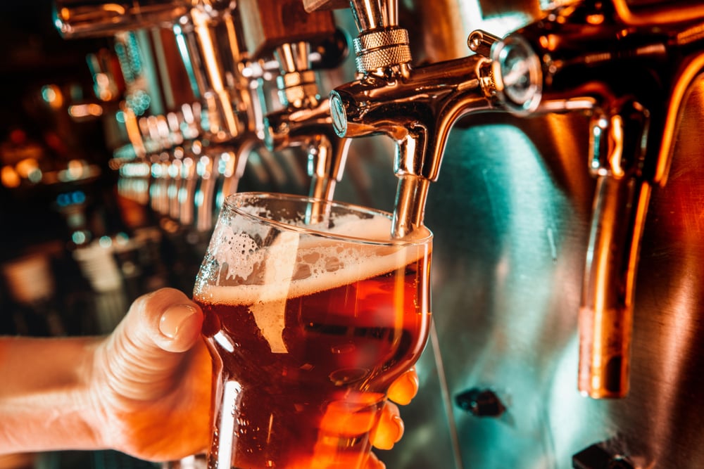 hand of bartender pouring beer in tap