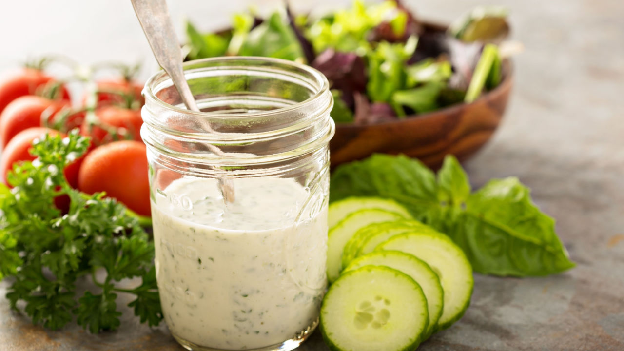 Homemade ranch dressing in a mason jar with fresh vegetables