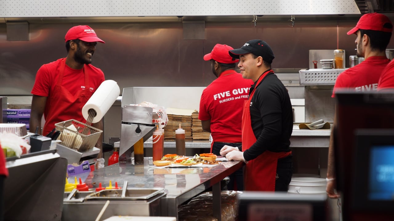 Closeup of crews working at Five Guys burger chain