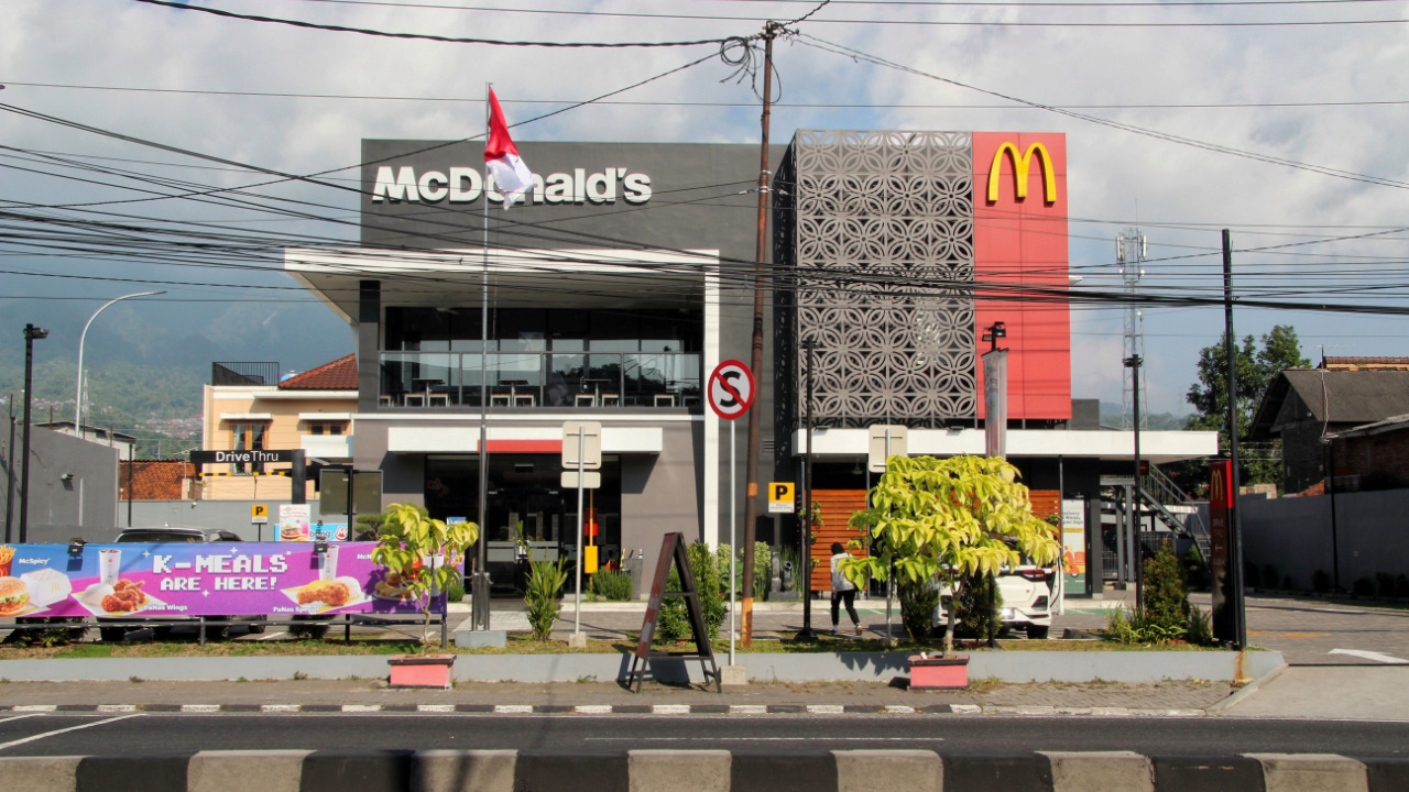 the front view of a McD outlet on the side of the road is decorated with transverse cables.