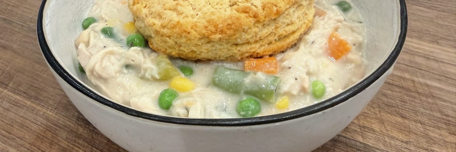 Bowl of crockpot chicken pot pie topped with a golden biscuit
