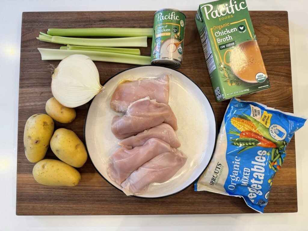 Ingredients for crockpot chicken pot pie: chicken breasts, Yukon gold potatoes, onion, celery, chicken broth, cream of chicken soup and frozen mixed vegetables