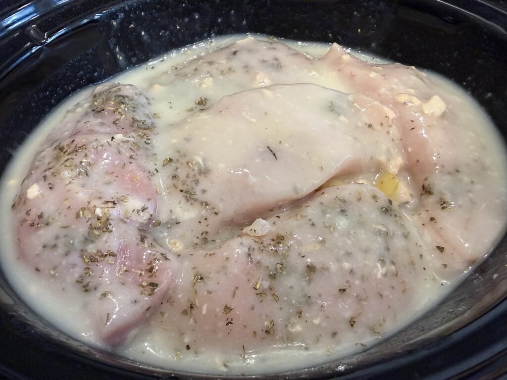 Soup and broth mixture poured over the chicken in the slow cooker